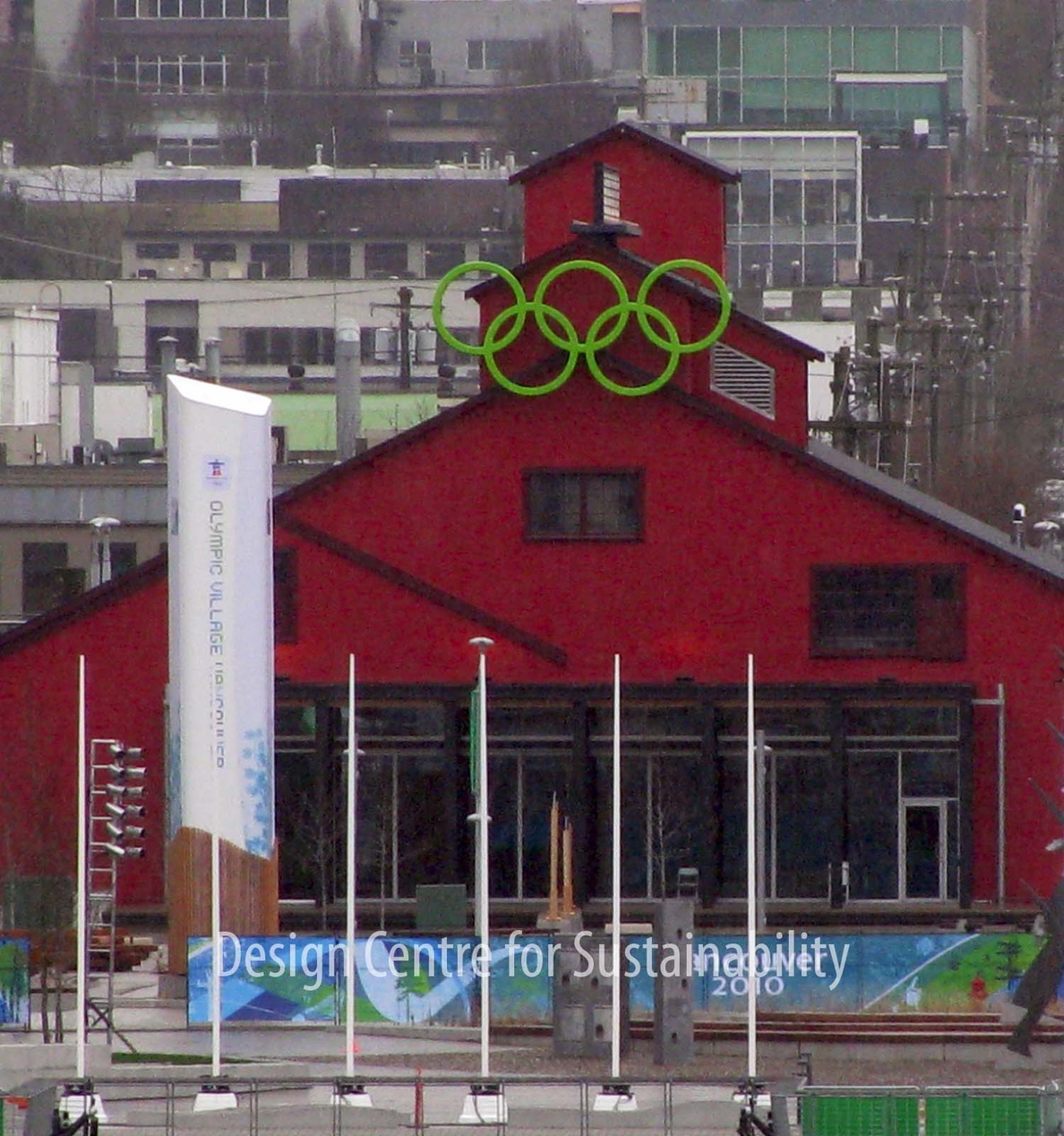 Röd byggnad 'Design Centre for Sustainability' med olympiska ringar, symbol för hållbar design.
